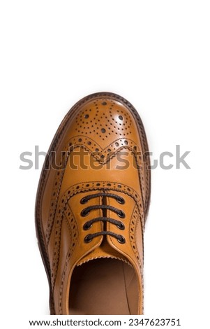 Closeup of Tip Medalion of One Brogue Derby Shoe of Calf Leather with Rubber Sole Over Pure White Background. Vertical image