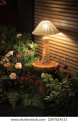 The wooden lamp above the round table with fresh flower pink babys breath and roses concept decoration in living room

