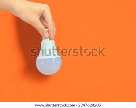 This is a picture of holding a light bulb. By using the backlight as an orange power indicator