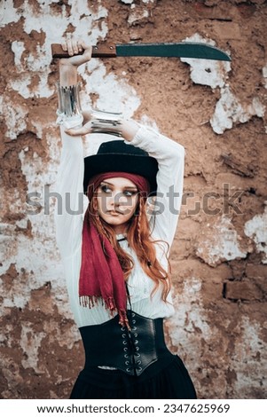 Outdoor portrait of young female in pirate costume with a machete. Copy space