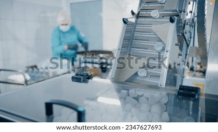 Feeding conveyor for transporting products to the filling and packaging machine. Transportation of products to the packaging machine. Production line of medical dietary supplements. Pharma factory Royalty-Free Stock Photo #2347627693
