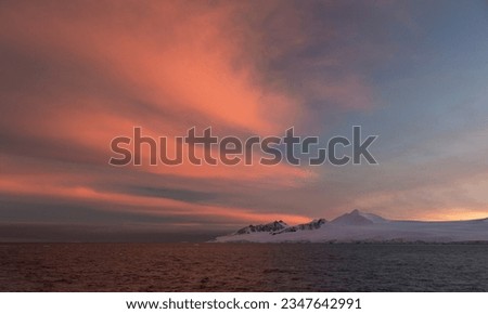 Sunlit berg, shadowed mountainside; Sunlit mist, on the mountain; Sunlit snow, ridge reflection; Sunset clouds, over brash ice; distant icebergs; Errera Strait; Dorian Bay, blue bergs; Antarctica