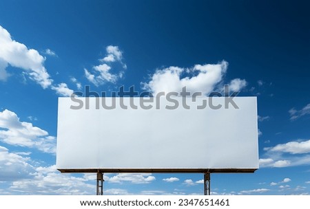 View of a white billboard sign with blue sky and clouds background