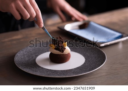 Skilled chef meticulously garnishing dessert with rich chocolate, creating an exquisite culinary masterpiece in elegant fine dining setting Royalty-Free Stock Photo #2347651909