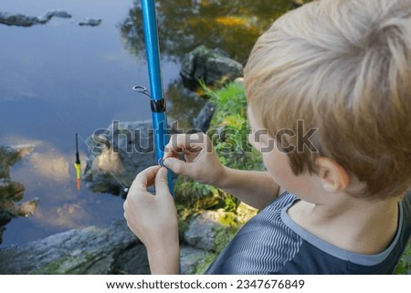 In the teenager's hands is the bait he puts on the hook. Sport fishing on the river in summer.