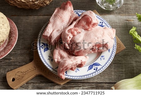 Frozen chicken backs and fresh vegetables - Ingredients for bone broth or soup on a table
