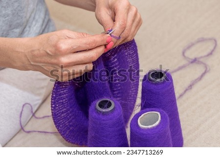 hands of woman knitting handmade clothes with spokes using  wool yarn. Concept of leisure activity.Knitting from yarn on  coarse spokes.