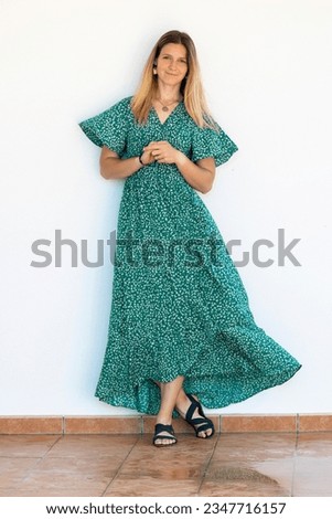 Cute blond girl with green dress over a white background.