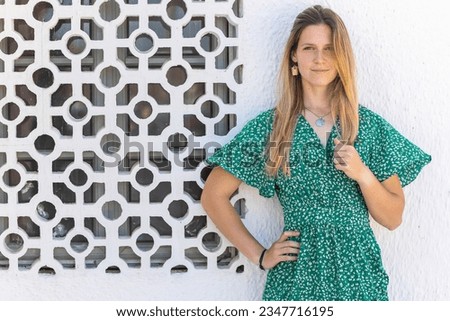 Cute blond girl with green dress over a white background.