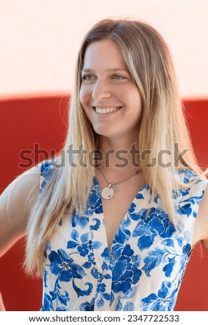 Close view of a cute blond girl portrait with blue dress smiling.