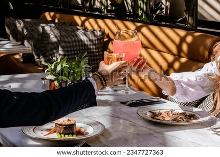 two hands cheering liquor glasses, whiskey and cocktail, fine dining restaurant Royalty-Free Stock Photo #2347727363