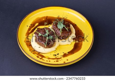 steak minion on potatoes in a plate on a dark background