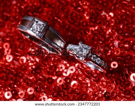 Wedding rings on glitter red background. Modern wedding ring. Beautiful wedding or engagement ring symbol.