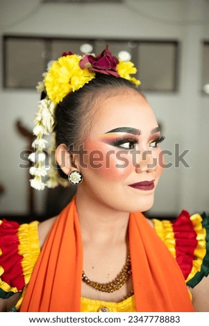 beautiful face of a traditional Indonesian dancer wearing flowers and charming makeup before performing on stage