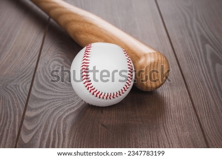 Closeup of baseball bat and ball on wooden table