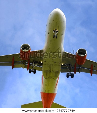 A plane from the side approaching for landing, against the background of clouds. Airplane close-up