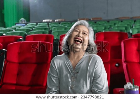 All emotional at the movies. Senior asian woman looking shocked and surprised while sitting at the cinema auditorium during movie premiere entertainment leisure hobby expressive emotions shock concept
