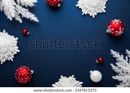 Merry Christmas and Happy Holidays greeting card, frame, banner. New Year. Noel. White Christmas white and red ornaments on blue background top view. Winter holiday xmas theme. Flat lay. Royalty-Free Stock Photo #2347815373