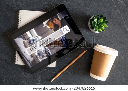 Top view of digital tablet with search job on screen on a table.