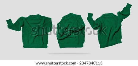 Cut out clothing. Warm cotton woolen knitted sweater, pullover, jacket. Green flying knitted sweater isolated on gray background. Mockup, object for design. Clothes levitation concept Royalty-Free Stock Photo #2347840113