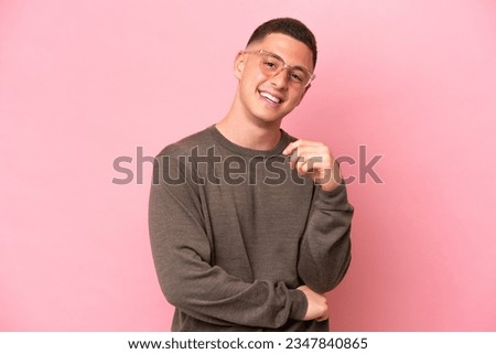Young Brazilian man isolated on pink background laughing Royalty-Free Stock Photo #2347840865