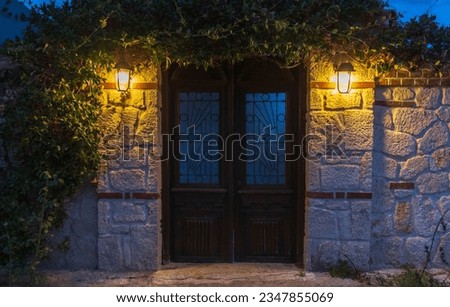 Old wooden door at night in Kassandra, Greece, Europe. Royalty-Free Stock Photo #2347855069