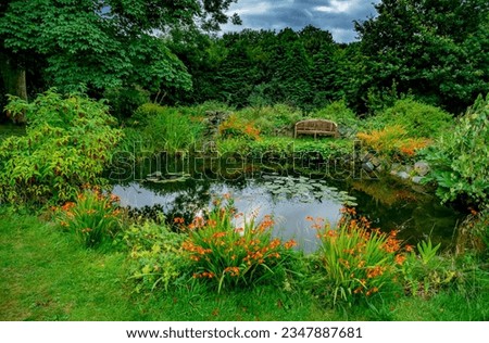 Inviting bench overlooking a pond and the garden in the rural English countryside