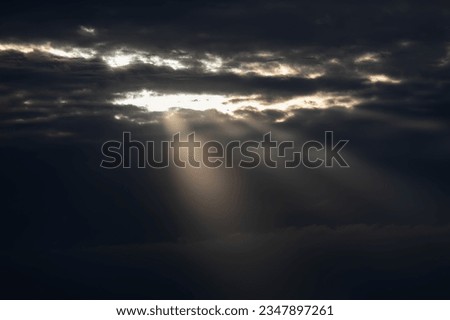 Sun rays through the clouds in the sky. The sun shines through the clouds.