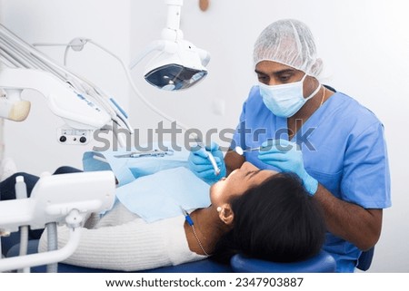 Dentist checking teeth of patient woman sitting in medical center Royalty-Free Stock Photo #2347903887