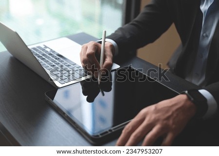 Closeup of businessman working, using stylus pen signing e-document on digital tablet. Business man planning work project, proofing digital document on office table, E-signing, electronic signature Royalty-Free Stock Photo #2347953207
