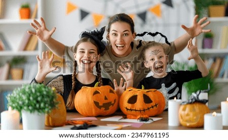Happy family preparing for Halloween. Mother and children in carnival costumes at home. Royalty-Free Stock Photo #2347961195