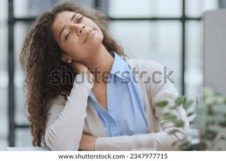 Tired business woman sitting at office desk and working