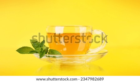 Soothing herbal tea blend with mint. On yellow background Royalty-Free Stock Photo #2347982689