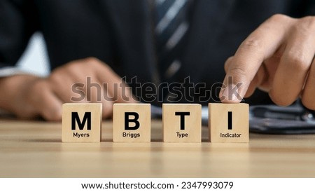 MBTI,Myers-Briggs Type Indicator.Psychological and personality test concept.Businessman and MBTI word on wood cubes.