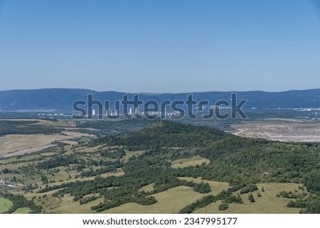 View from the Bořeň hill to the lignite surface mine, the town of Chomutov and the Ore Mountains in the background. Important tourist site, protected landscape area.