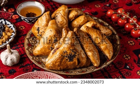 The concept of Eastern cuisine. Uzbek samsa lies on a plate in a restaurant. Royalty-Free Stock Photo #2348002073