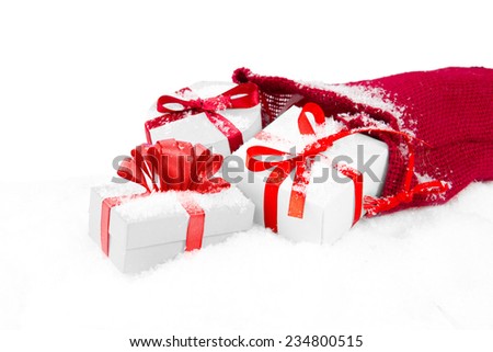 Still life with Christmas gifts in a red bag with snow isolated on white