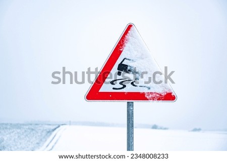Snow covered traffic sign, Danger of skidding when wet or dirty