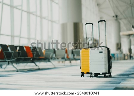 Two suitcases in an empty airport hall, traveler cases in the departure airport terminal waiting for the area, vacation concept, blank space for text message or design Royalty-Free Stock Photo #2348010941