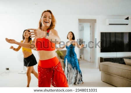 Picture a group of female friends performing Belly Dance in beautiful costumes. with fun at their homes, woman dance, Belly dancer in legging,s and hip scarf dancing. Royalty-Free Stock Photo #2348011031