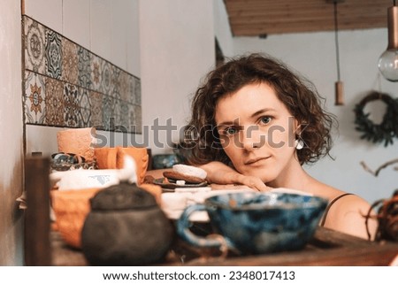 Portrait of a young Caucasian woman sculptor in home workshop for the manufacture of pottery.Small business,entrepreneurship,sustainability,hobby,leisure concept. 
