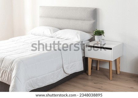 contemporary bedroom interior with Modern Upholstered Headboard, white bed featuring a cozy blanket Royalty-Free Stock Photo #2348038895