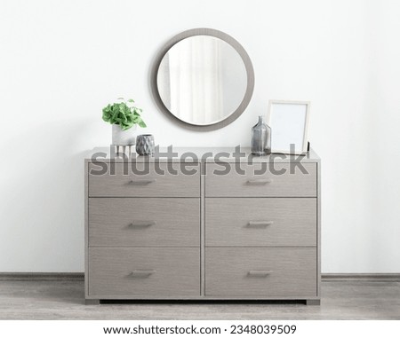 Modern gray chest of Drawer Double Dresser with mirror and plant on floor inside a modern room Royalty-Free Stock Photo #2348039509