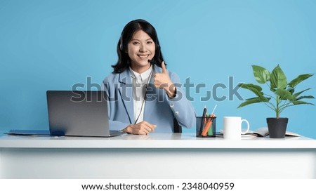 image of an asian consultant using a laptop on a blue background