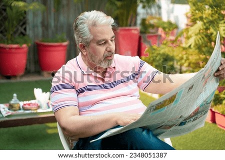 Old man reading news paper and giving shocking expression. lifestyle concept.