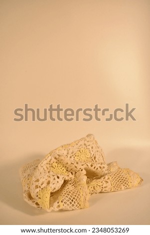 Handcrafted lace fabric created by crocheting small threads of yellow and white silk with empty space. The picture gives a warm feeling.