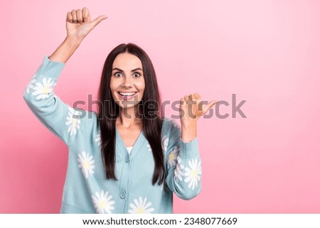 Photo of sweet impressed woman dressed blue cardigan showing two fingers empty space isolated pink color background