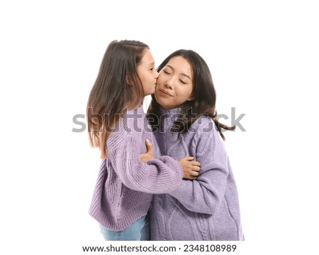 Asian little girl kissing her mother on white background