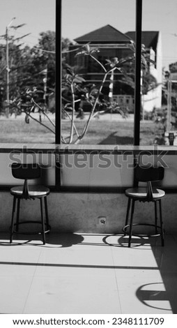 two empty chairs in front of the window with sunlight from the side with a warm atmosphere