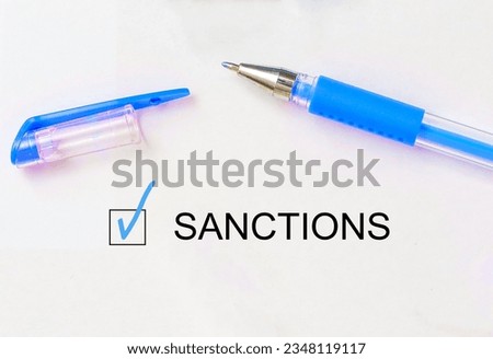check mark on the word sanctions and crossed lines and pen. Closeup, concept